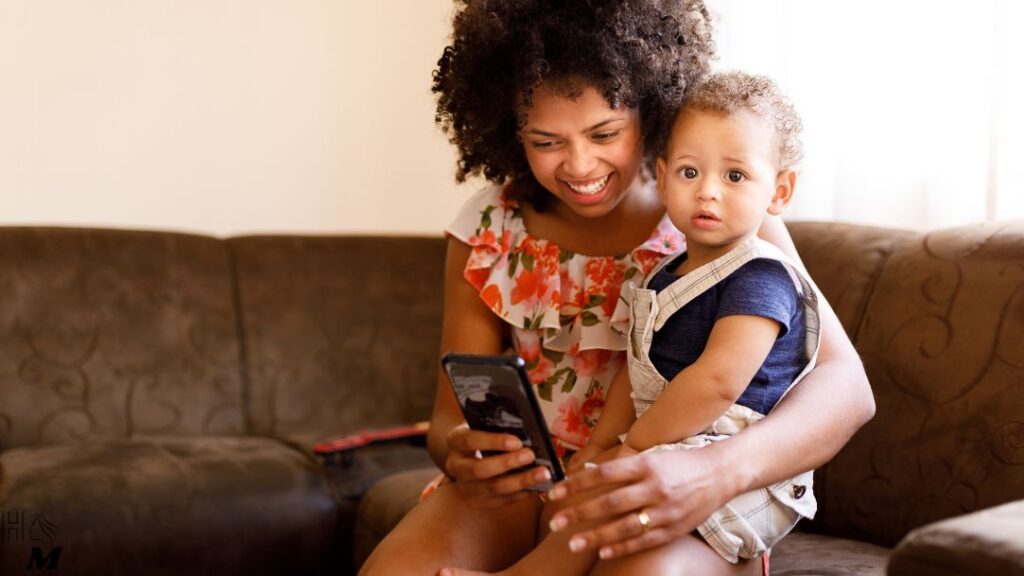 mãe com criança e celular no colo